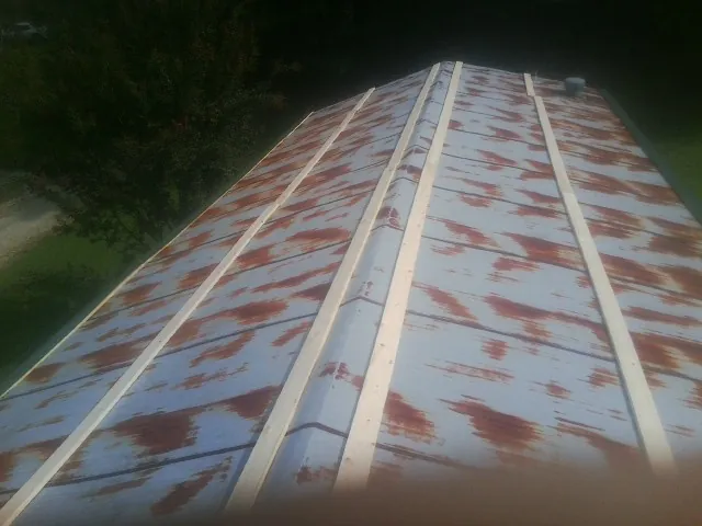 Rusted metal roof panels with new wood purlins before replacement — Storm Damage Roof Repair in Farmersburg by Roofing Brothers