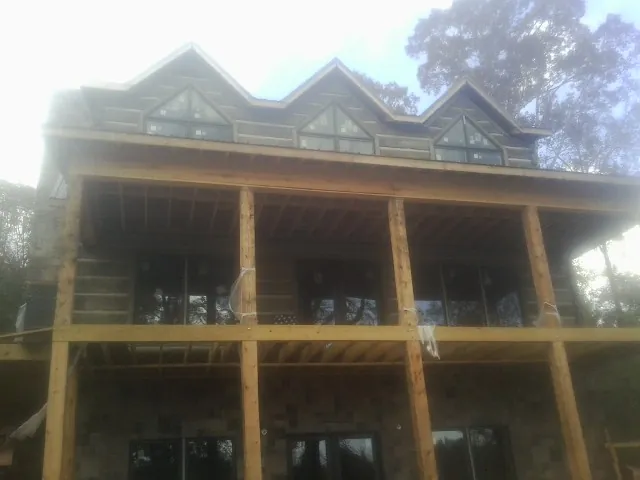 Dormers and porch framing on a large log home under construction — Roof Coating work by our crew in Farmersburg