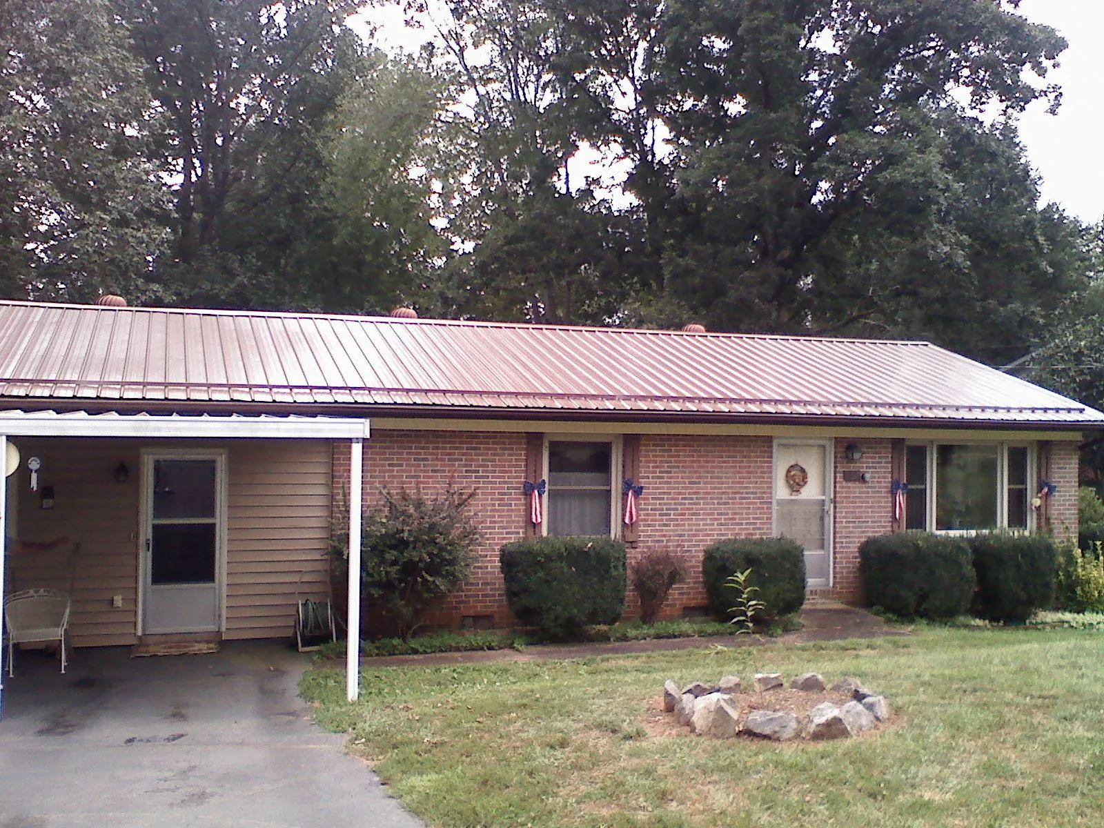 Bronze metal roof and carport on a brick ranch home — Roof Repair work by our crew in Farmersburg